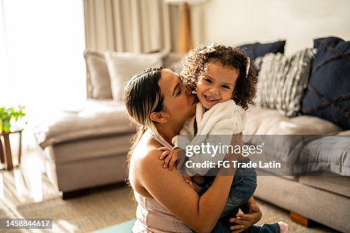 Portrait of toddler girl having fun with her mother in the living room at home