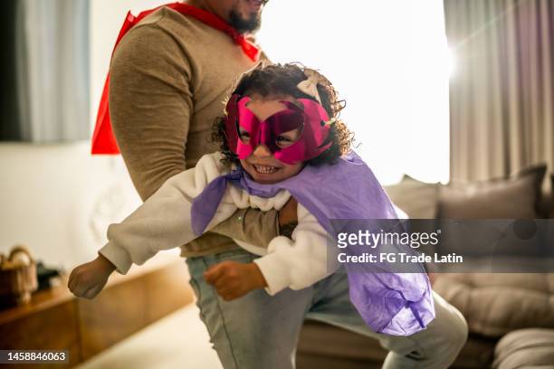 father and daughter playing superhero in the living room at home - real life hero stock pictures, royalty-free photos & images