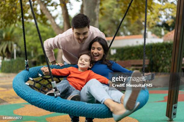 família brincando no balanço no parque - swing - fotografias e filmes do acervo