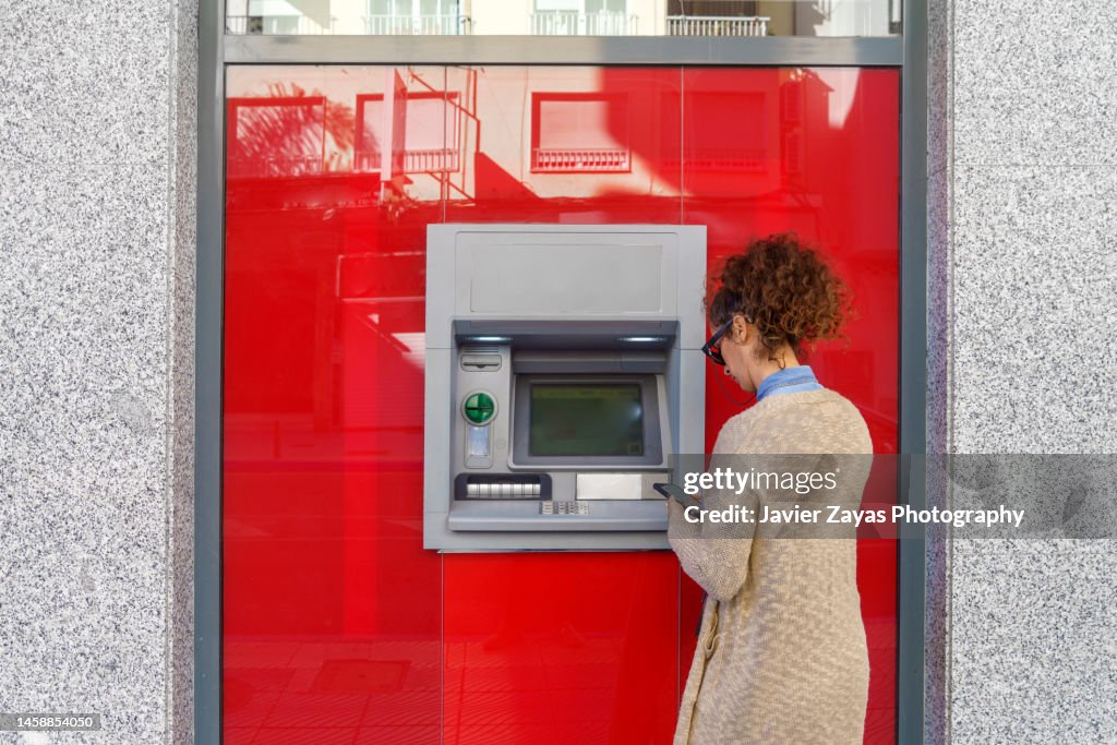 Latin woman using ATM
