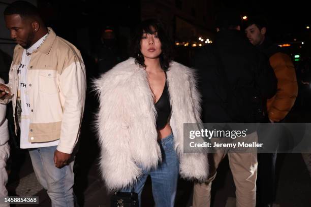 Fashion week guest seen wearing a black Louis Vuitton bag, a jean, a black croptop and a white fluffy fur jacket before the KidSuper show on January...