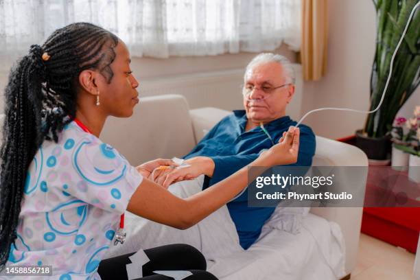 nurse attaching iv drip on patient - medical oxygen stock pictures, royalty-free photos & images