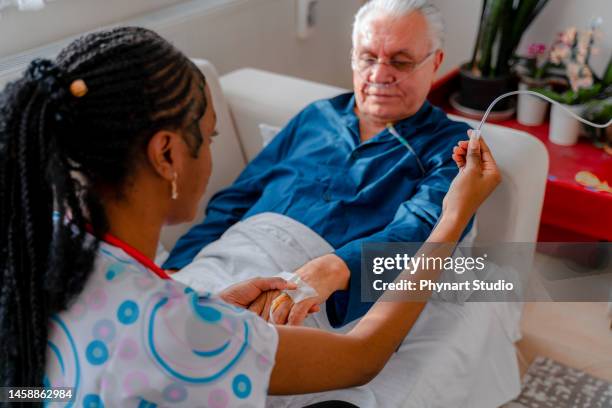 nurse attaching iv drip on patient - chemotherapy stock pictures, royalty-free photos & images