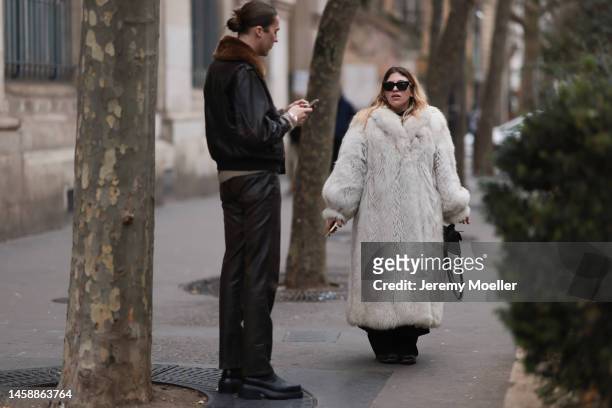 Fashion week guest seen wearing a white fluffy fur coat and another fashion week guest seen wearing a matching lather jacket and brown leather pants...