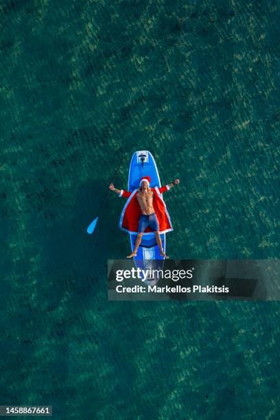 santa on the sup - surfing santa stock pictures, royalty-free photos & images