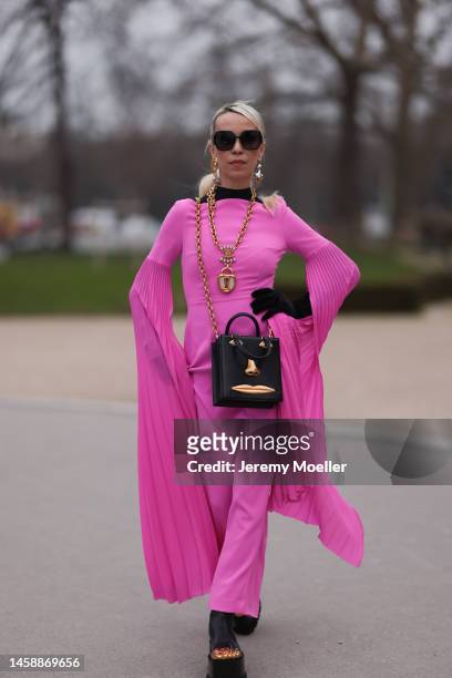 Denisa Palsha seen wearing a pink Schiaparelli long dress, black shades, black big Schiaparelli bag, black Schiaparelli Plateau shoes and gold...