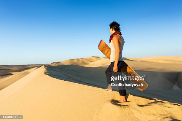young woman sandboarding in the sahara desert, africa - western sahara desert stock pictures, royalty-free photos & images