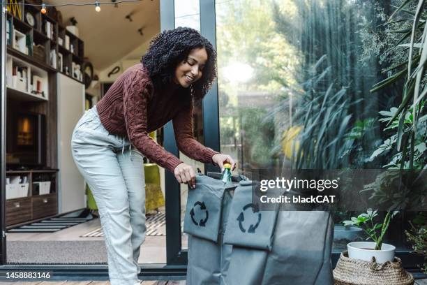 mujer clasifica desechos plásticos en el patio trasero - industrial garbage bin fotografías e imágenes de stock