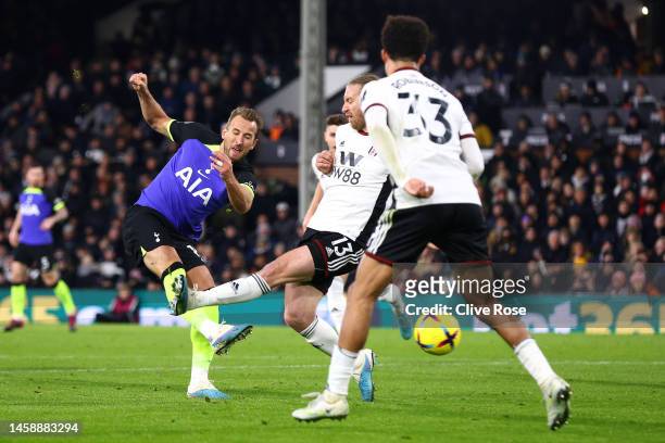Harry Kane of Tottenham Hotspur has a shot whilst under pressure from Tim Ream of Fulham during the Premier League match between Fulham FC and...