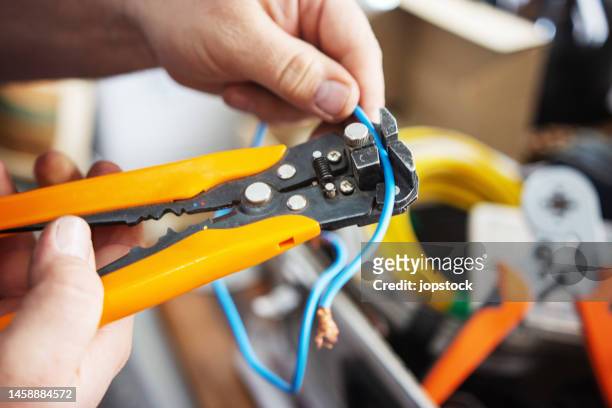 electrician using wire stripping pliers - man cutting wire stockfoto's en -beelden