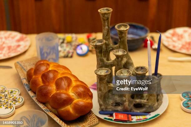 table setting to celebrate hanukkah with challah and menorah, on the second night of hanukkah - braided bread stock pictures, royalty-free photos & images