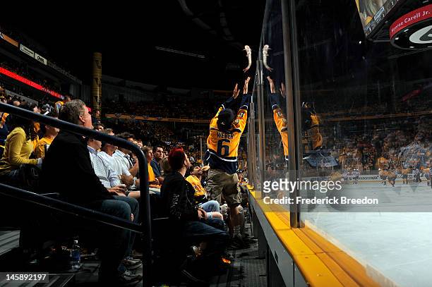 Fan throws a catfish onto the ice in Game Four of the Western Conference Semifinals with the Phoenix Coyotes and Nashville Predators during the 2012...