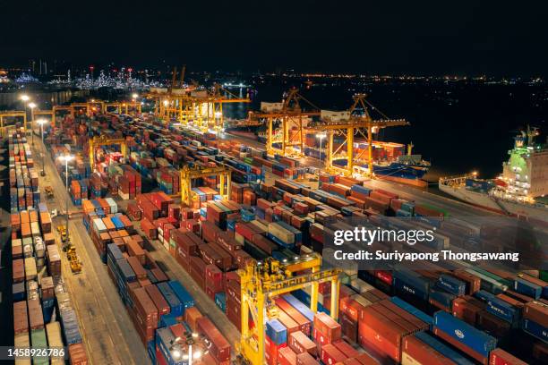 aerial view terminal commercial port for unload container to container cargo ship at night, business logistics import export shipping or freight transportation. - shipyard aerial stock pictures, royalty-free photos & images