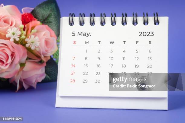 calendar desk 2023: may is the month for the organizer to plan and deadline with a flower handcrafted against a blue paper background. - may month stock pictures, royalty-free photos & images