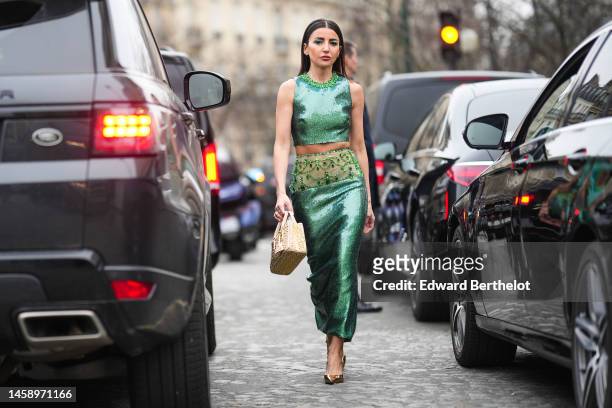 Alexandra Pereira wears gold earrings, a green embroidered sequined with large green rhinestones collar cropped top, a matching green sequined with...