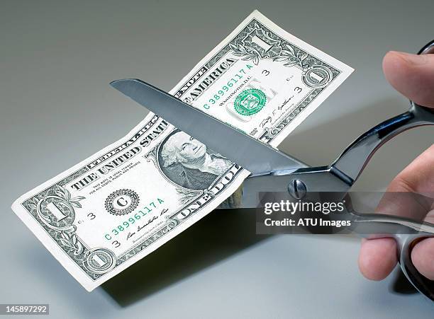 Dollar bill being cut with scissors