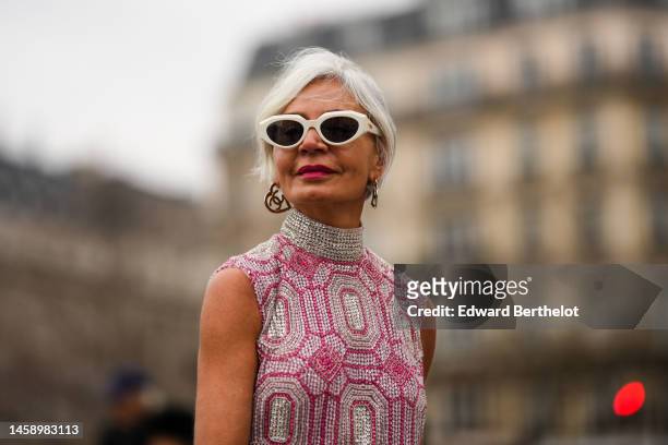 Grece Ghanem wears white sunglasses, silver earrings from Chanel, a silver and pink embroidered rhinestones pattern turtleneck / sleeveless long...