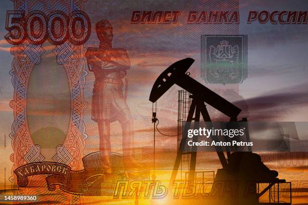 oil pump on the background of russian rubles bill. world oil industry - geldstrafe stock-fotos und bilder