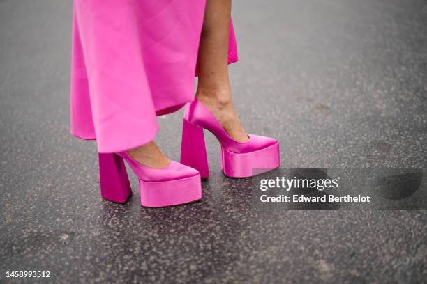 Guest wears a neon pink cut-out chest / long sleeves / slit dress, pink pointed platform heels shoes , outside Georges Hobeika, during Paris Fashion...