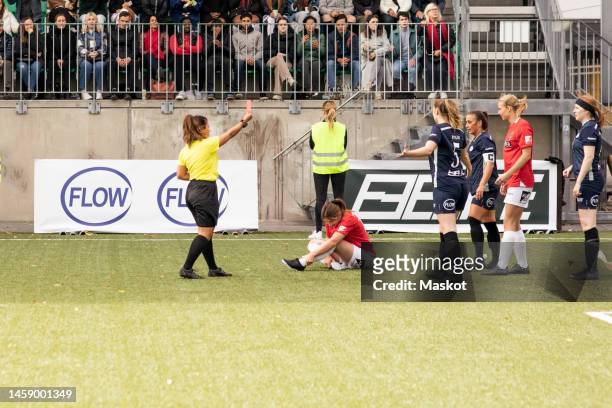female referee showing red card to soccer players during match in stadium - referee card stock pictures, royalty-free photos & images