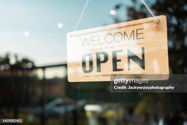 close up of open sign on glass door to a bakery. - rótulo con el horario fotografías e imágenes de stock