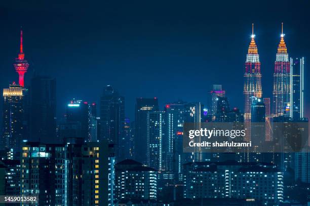 petronas twin towers glowing with cyberpunk colours during chinese new year celebration in kuala lumpur. - kuala lumpur twin tower stock pictures, royalty-free photos & images