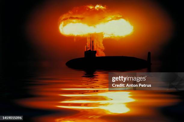 submarine on the background of a nuclear explosion - radioaktive verseuchung stock-fotos und bilder