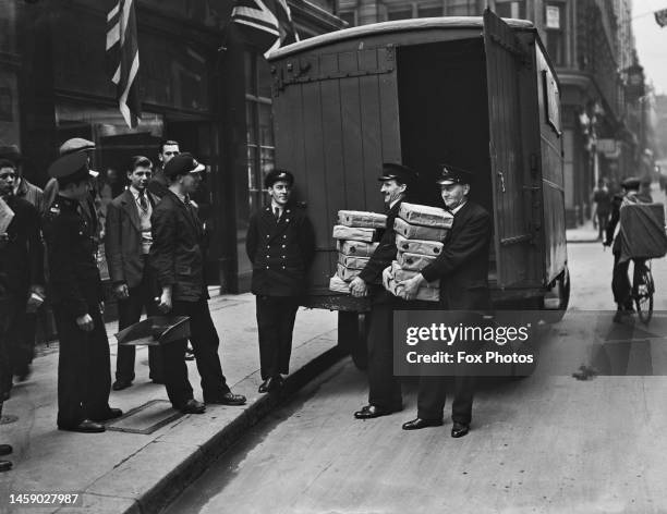 Delivery drivers carry some of the 92 parcels of Coronation stamps issued by the 45 Crown Colonies, stamps which will be in demand by collectors,...