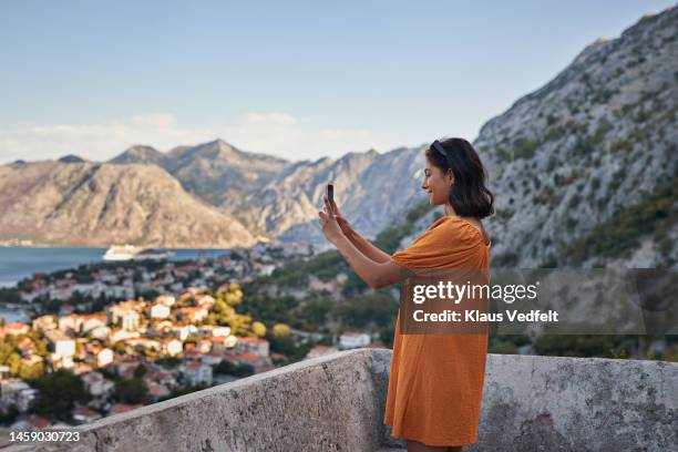 female tourist photographing cityscape through smart phone - profile shoot of bollywood actor parineeti chopra stockfoto's en -beelden