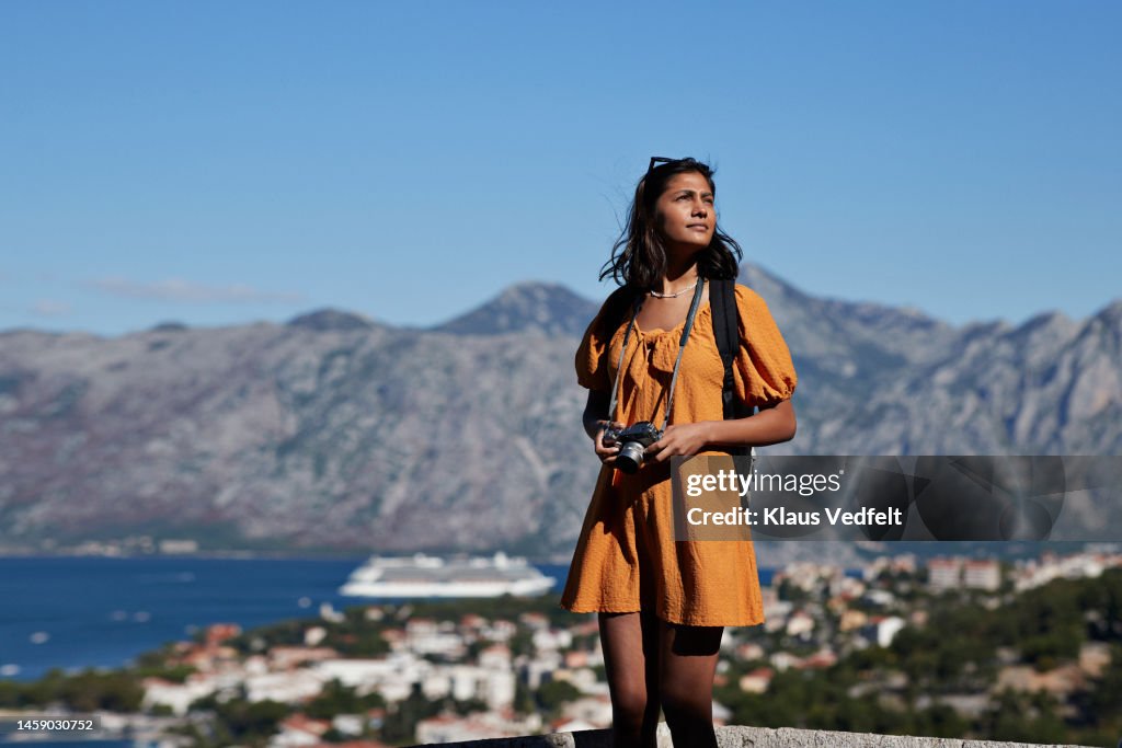 Female tourist with camera against mountain range