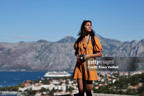 female tourist with camera against mountain range - indian ethnicity travel stock pictures, royalty-free photos & images