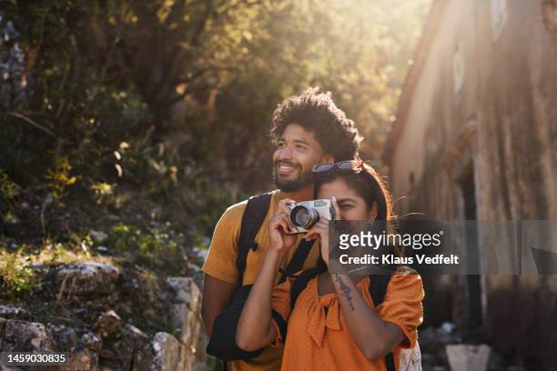 woman photographing through camera by boyfriend - travel photos et images de collection