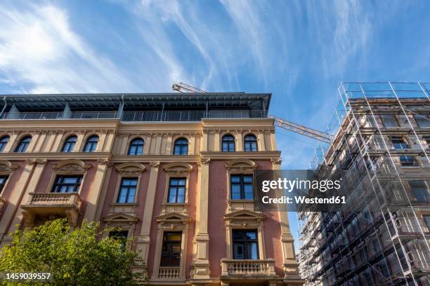 germany, bavaria, munich, palais ingenheim-molitor office with crane looming in background - munich stock pictures, royalty-free photos & images