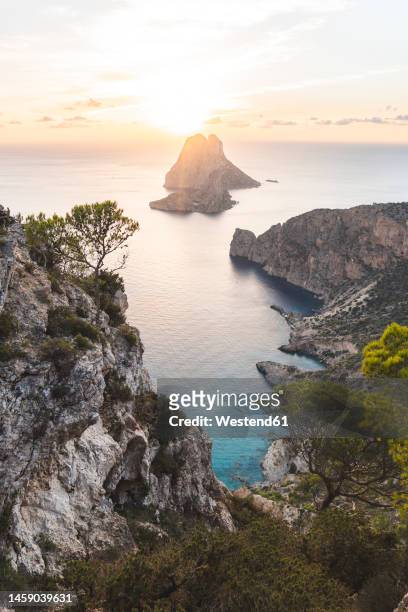 spain, balearic islands, cliffs of ibiza island at sunset with esvedrain background - ibiza island stock pictures, royalty-free photos & images