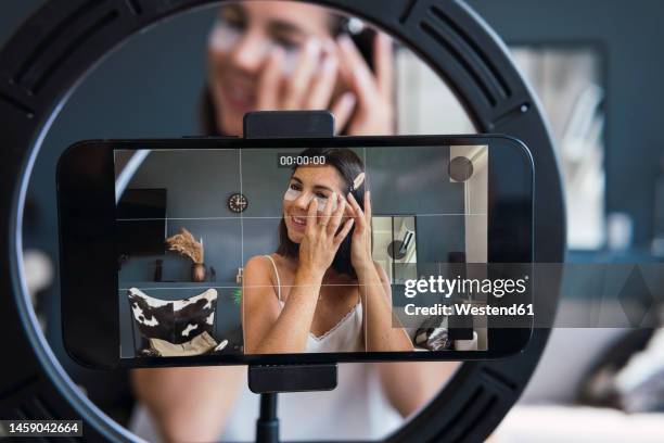 young woman recording skin care tutorial on smart phone at home - ring light stock pictures, royalty-free photos & images