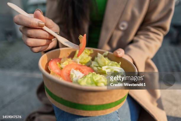 young woman having bowl of salad - salad bowl stock-fotos und bilder