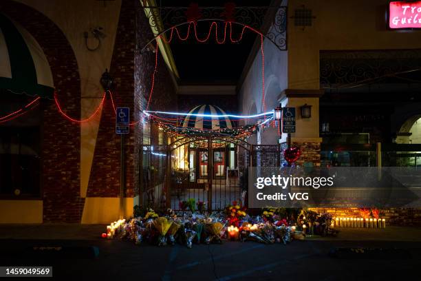 Flowers are laid for victims of a mass shooting outside the Star Dance Studio on January 23, 2023 in Monterey Park, California. At least 10 people...