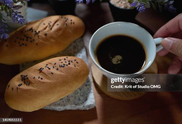 a cup of black coffee with homemade bread - close up bread roll black backdrop horizontal stock pictures, royalty-free photos & images