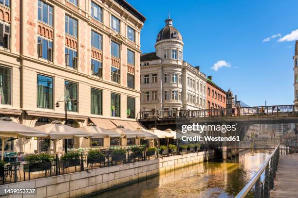 denmark, aarhus, sidewalk cafe along aboulevarden promenade with bridge in background - aarhus stock pictures, royalty-free photos & images