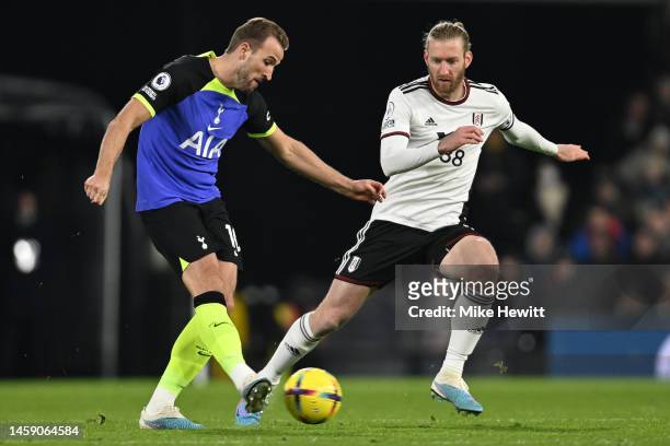 Harry Kane of Tottenham Hotspur passes the ball under pressure from Tim Ream of Fulham during the Premier League match between Fulham FC and...