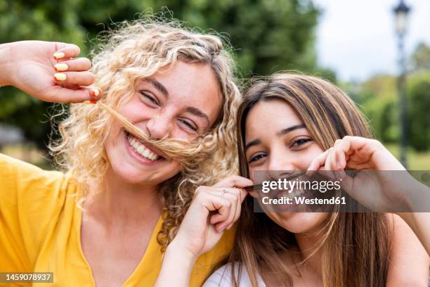 happy friends with hair mustache in park - bigode imagens e fotografias de stock