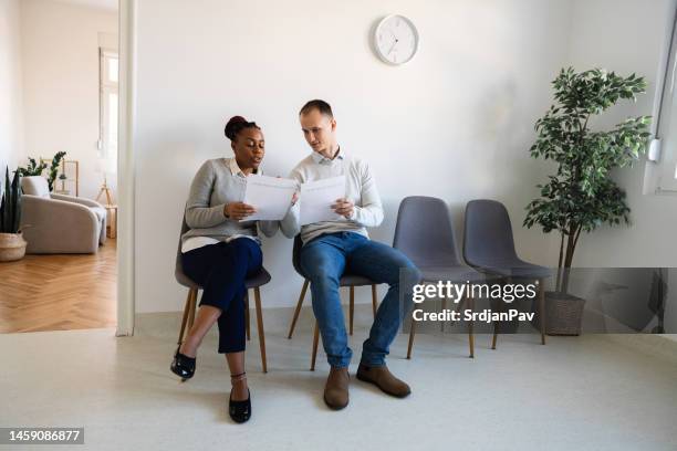 female and male candidates compare their resumes while waiting for a job interview - interview preparation stock pictures, royalty-free photos & images