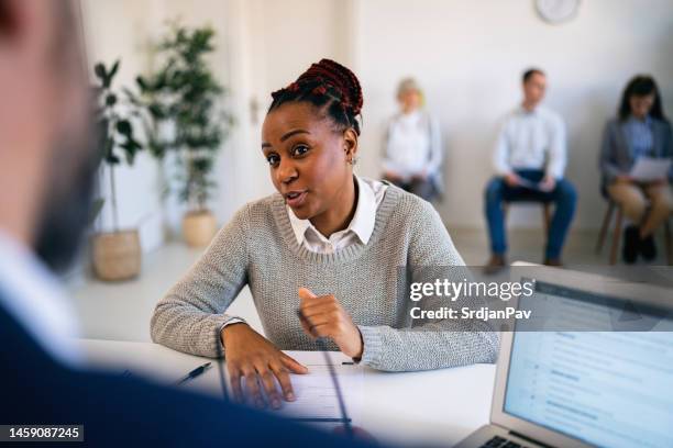 woman of black ethnicity having an job interview with male recruiter - recruiter stock pictures, royalty-free photos & images