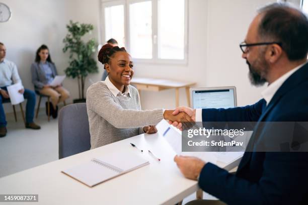 female candidate of black ethnicity handshake with the recruiter at job interview - job search stock pictures, royalty-free photos & images