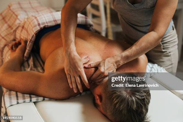 home visit massage therapist. massage at home in the kitchen. a woman makes massage to a man indoors at home. - occupational therapy kitchen photos et images de collection