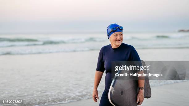 senior woman in neoprene with surf. - old people diving stock pictures, royalty-free photos & images