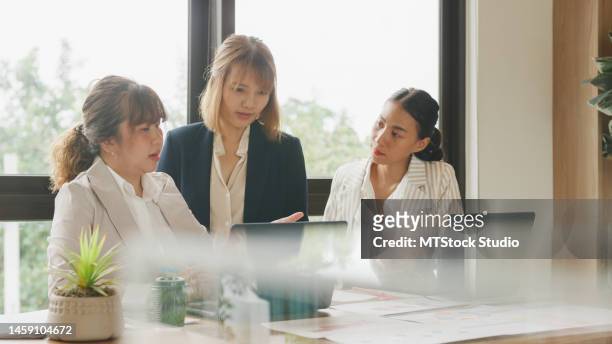 役員室で同僚に新しい戦略を説明する女性起業家。ビジネスマンの多民族チームが、オフィスでの企業会議中にプロジェクトについてブレインストーミングします。金融会社。 - team lunch ストックフォトと画像