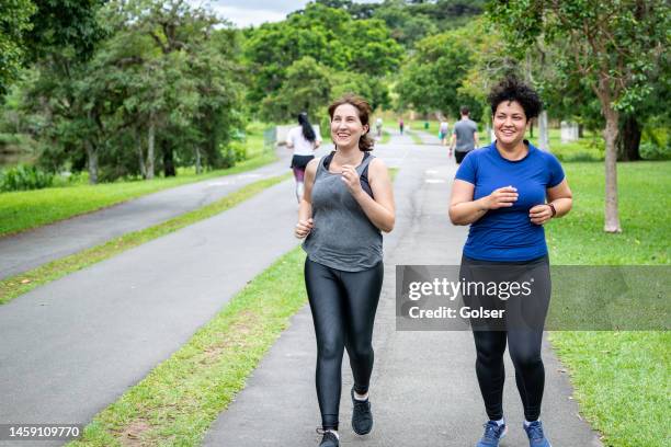 zwei freundinnen joggen im park - curitiba stock-fotos und bilder