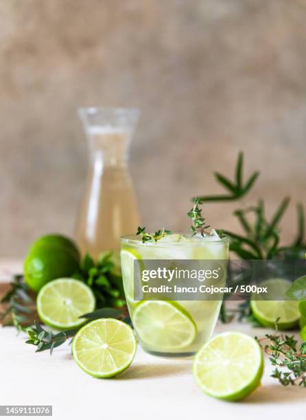 cold refreshing summer drink or lemonade with lime and thyme on concrete background,romania - mojito stock pictures, royalty-free photos & images