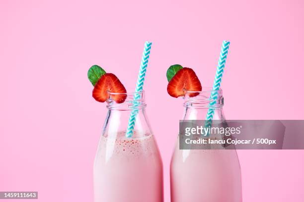 close-up strawberry smoothie or milkshake in glass jar with berries on pink background summer drink,romania - strawberry milkshake stock pictures, royalty-free photos & images